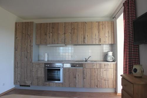 una cucina con armadi in legno e piano cottura di Urlaubshof Grimm a Egling