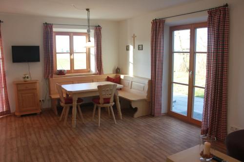 un soggiorno con tavolo, sedie e finestra di Urlaubshof Grimm a Egling