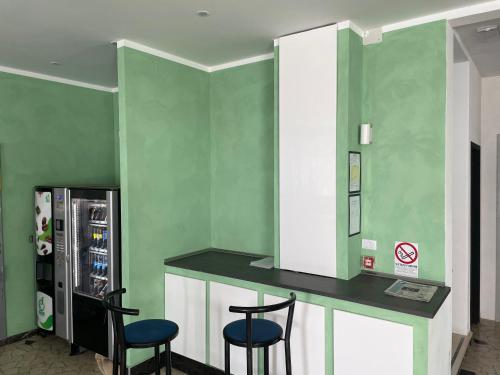 um bar com dois bancos e um frigorífico em Hotel Rosa em Rimini