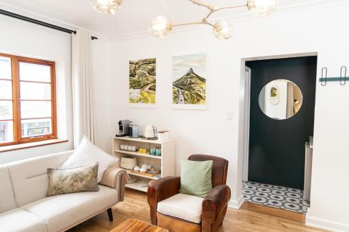 a living room with a couch and a chair at Boho Chic Studio Stellenbosch in Stellenbosch