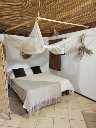 - une chambre avec un lit et une moustiquaire dans l'établissement Auberge Keurmariguen, à La Somone