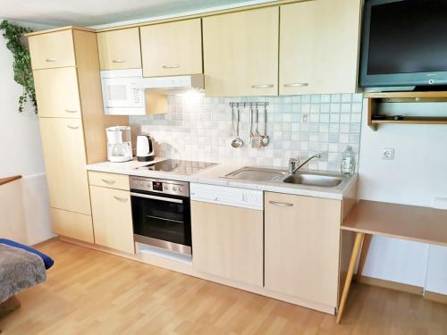 a small kitchen with white cabinets and a sink at Haus Marienheim in Heiligenblut