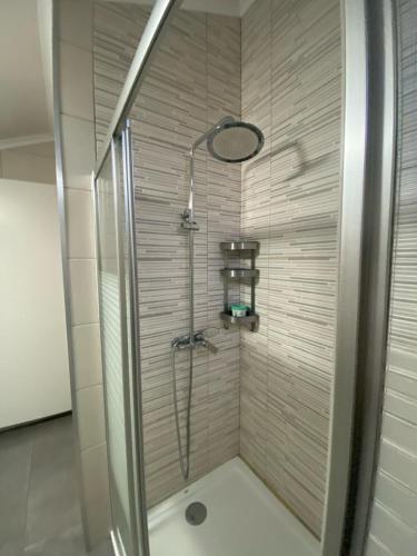a shower with a glass door in a bathroom at Alojamento Quadros in Horta