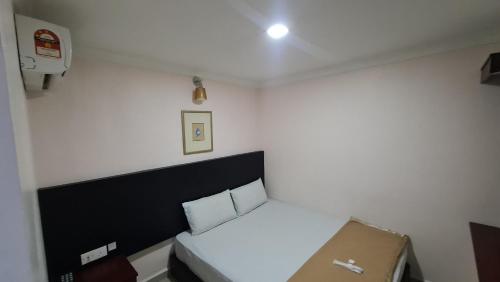 a small bedroom with a bed and a box at SP Venture Boutique Hotel in Rawang