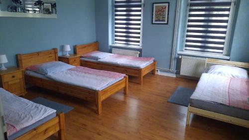 3 łóżka w pokoju z drewnianymi podłogami i oknami w obiekcie FEWO1-1 Zim Apart-4 Bett-Küche-Dusche WC-Parkplatz w Berlinie