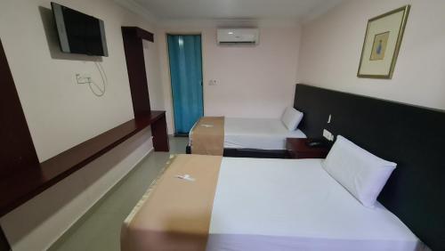a hotel room with two beds and a television at SP Venture Boutique Hotel in Rawang