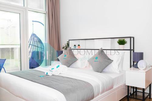 um quarto com uma cama branca com dois bichos de peluche em Modern 1 Bedroom In Oasis2 em Abu Dhabi