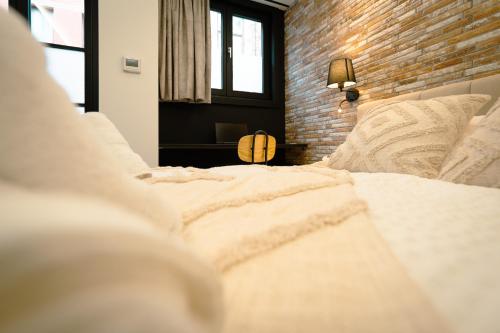 a bedroom with a large white bed with a brick wall at Le Pèlerin in Mons