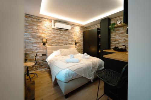 a bedroom with a bed and a brick wall at Le Pèlerin in Mons