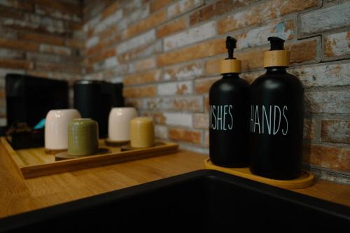two black bottles sitting on a counter with candles at Le Pèlerin in Mons
