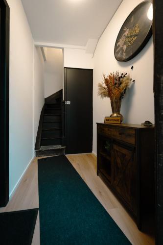 a hallway with a black door and a green rug at Le Pèlerin in Mons