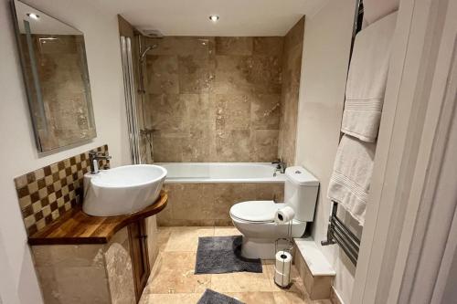 a bathroom with a sink and a toilet and a tub at No.1 - The Marilyn in Banbury