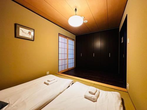 two beds in a small room with a window at Kyoto - House - Vacation STAY 13833 in Kyoto