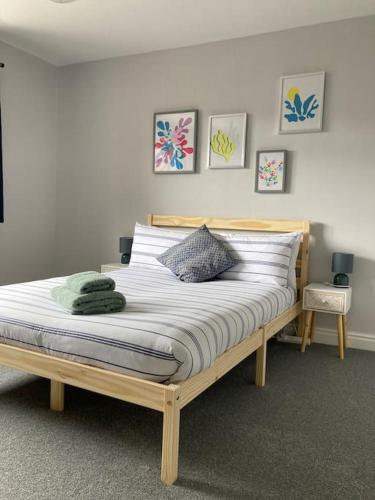 a bedroom with a large bed with white sheets at Modern home for those on business or on holiday in Newport
