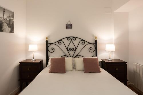 ein Schlafzimmer mit einem großen weißen Bett mit zwei Lampen in der Unterkunft Vidrio Urban Apartment in Sevilla