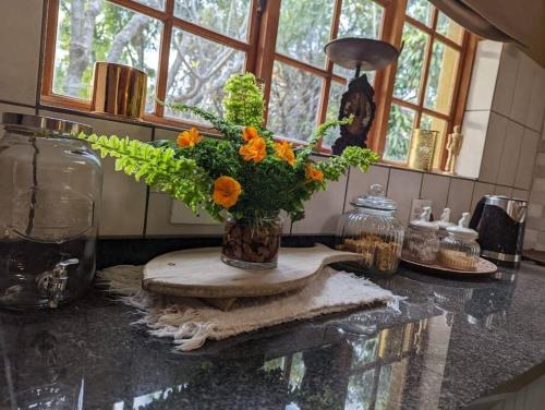 um vaso com flores num balcão na cozinha em Home away from home. Experience our farm luxury. em Tzaneen