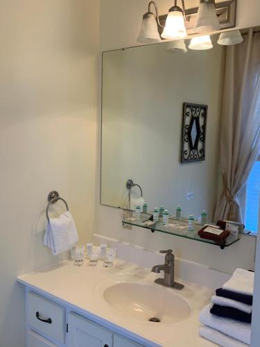 La salle de bains est pourvue d'un lavabo et d'un grand miroir. dans l'établissement Kennedy House, à Saint Andrews