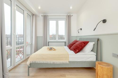 - une chambre avec un lit doté d'un oreiller rouge dans l'établissement Cozy Apartment with Balcony near Old Town Gdańsk by Rent like home, à Gdańsk