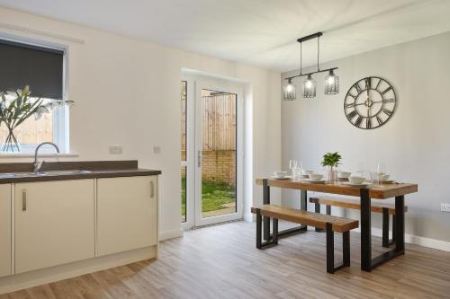 a kitchen with a table and a dining room at Home from Home - Mersey Way, Spacious 3 Bed, Perfect for Workers, Groups & Families, Netflix, FREE Parking & EV Charge Point in Sheffield