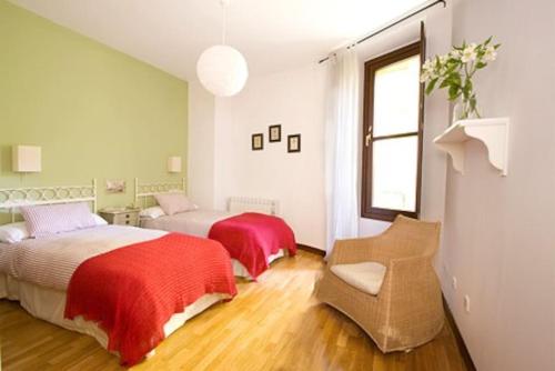 - une chambre avec deux lits, une chaise et une fenêtre dans l'établissement Apartamento Ría San Esteban, à San Esteban de Pravia