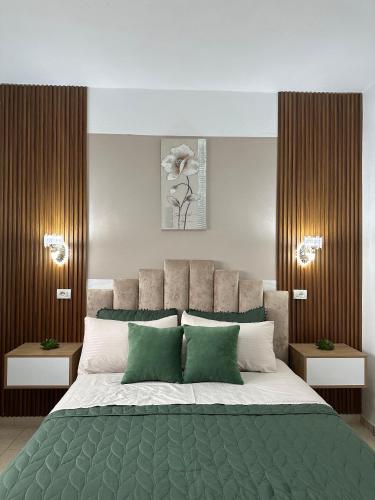 ein Schlafzimmer mit einem großen Bett mit grünen Kissen in der Unterkunft Feti Xhone Apartment in Ksamil