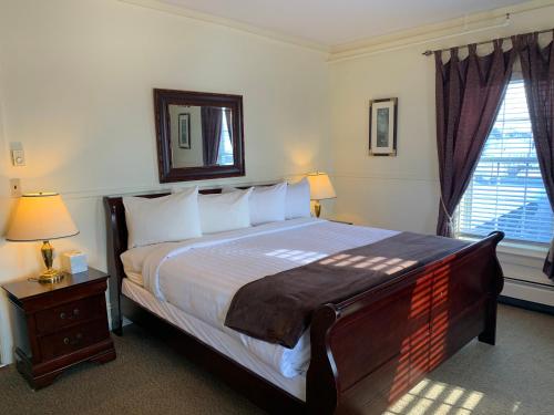 a bedroom with a large bed and a mirror on the wall at Kennedy House in Saint Andrews