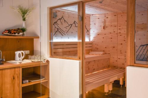 a sauna with wooden walls and a glass door at Lisas - with Wellness and Breakfast in Schröcken
