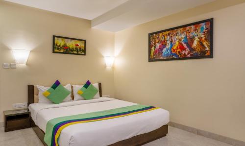a bedroom with a bed with a painting on the wall at Treebo Acsys, Gachibowli in Hyderabad