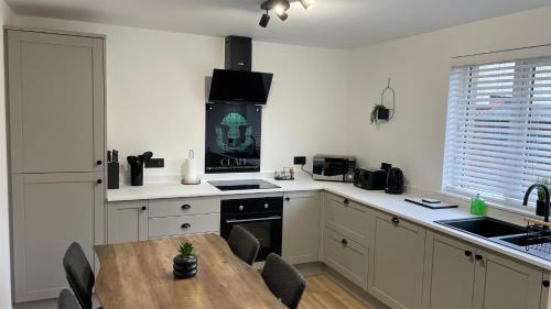 a kitchen with a wooden table and a dining room at Braeview, Contemporary Luxury NC500 Holiday Home - Sleeps 5 in Wick