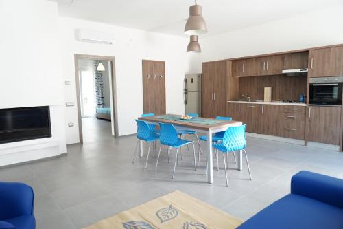 a kitchen with a table and some blue chairs at Tenuta Santa Maria in Mattinata