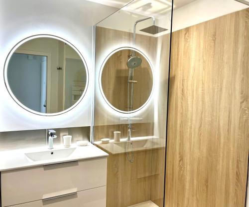 une salle de bain avec un lavabo et un miroir dans l'établissement Appartement refait à neuf - Superbe vue Grande Plage des Sables - 2 pers, à Les Sables-dʼOlonne