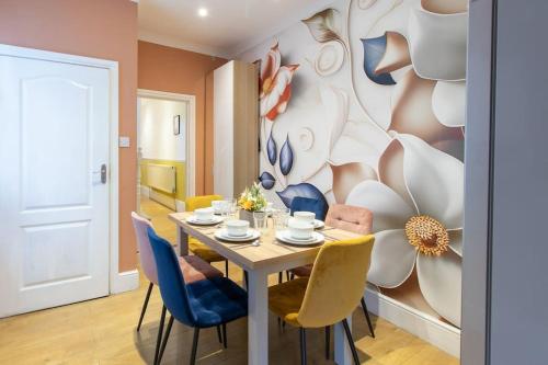 uma sala de jantar com uma mesa e cadeiras azuis em Open Mind Property - 5 Bedroom Lovely Home with Free Parking em Portsmouth