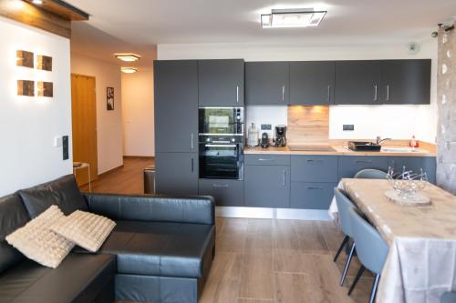 eine Küche und ein Wohnzimmer mit einem Sofa und einem Tisch in der Unterkunft High-end apartment 6 people capacity - Haut Combloux in Cordon