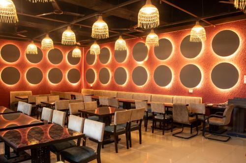 a restaurant with red walls and tables and chairs at J R Residency in Navi Mumbai
