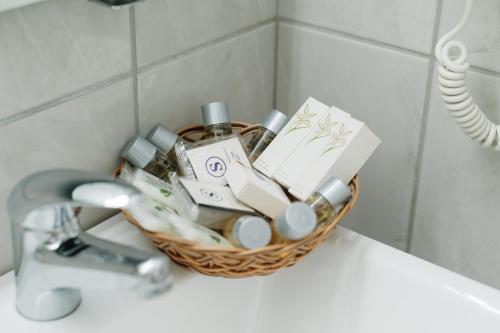 uma cesta de artigos de casa de banho sentados num lavatório em Hotel Slavija em Belgrado