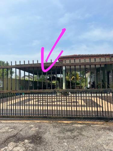 um sinal cor-de-rosa x numa vedação em frente a um edifício em Homestay Bajet Cikyah em Kepala Batas