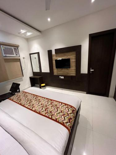 um quarto com uma cama e uma televisão de ecrã plano em Hotel SB Residency em Amritsar