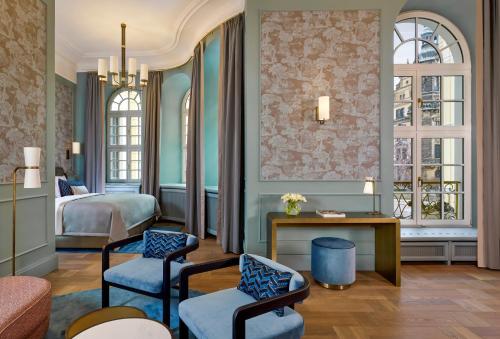 a hotel room with two beds and a table and chairs at Hotel Taschenbergpalais Kempinski in Dresden