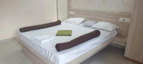 1 cama grande con sábanas blancas y almohadas. en RAJ RESORT & BANQUETS, en Vapi