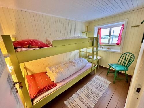 um quarto com 2 beliches e uma cadeira em Kleivan Cabin Lofoten em Kvalnes