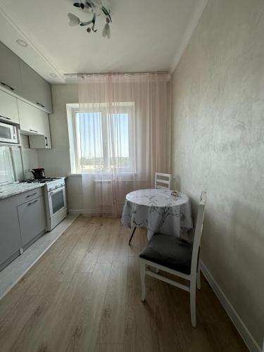 eine Küche mit Tisch und Stühlen in einem Zimmer in der Unterkunft Aksay distr in Almaty