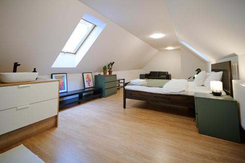 a bedroom with a large bed and a sink at Kesta Apartmán in Martin