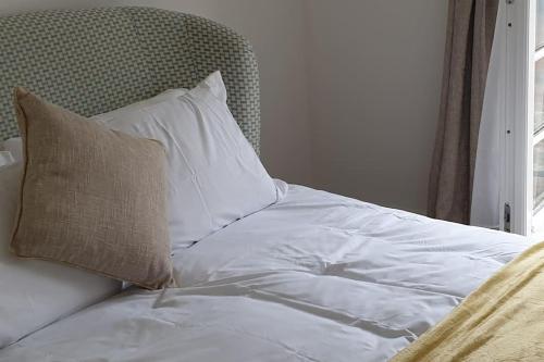 1 cama con sábanas blancas, almohada y ventana en No.9 - Park Place en Banbury
