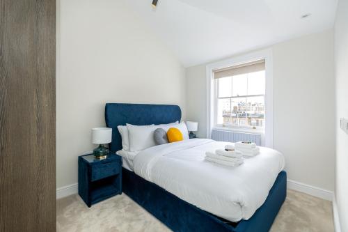 a bedroom with a blue bed with a window at Luxurious Central 4BR Mansion 2 min from Hyde Park in London