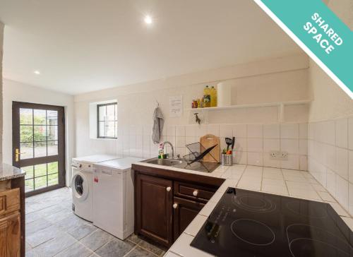 a kitchen with a sink and a dishwasher at Ventry Farm - Rainbow Cottage in Ventry