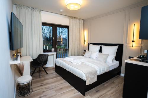- une chambre avec un lit, un bureau et une télévision dans l'établissement Julys Apartment Nr 2, à Oberhausen