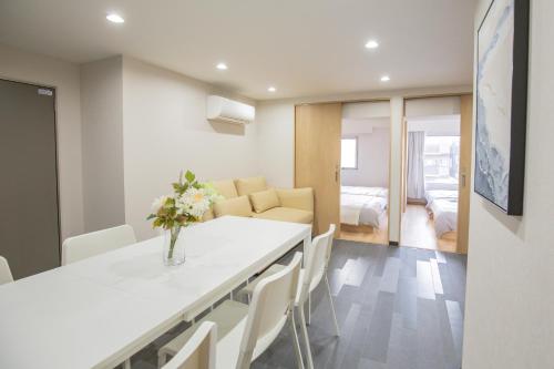 a kitchen and living room with a table and chairs at 1min walk to Higashi Shinjuku sta 8PPL Shinjuku Gyoen丶 National Garden丶 Kabukicho丶 Shinjuku Station丶 Golden Gai丶 Tokyo Metropolitan Government Building YYoQB in Tokyo