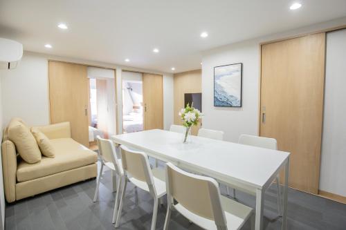a dining room with a white table and chairs at 1min walk to Higashi Shinjuku sta 8PPL Shinjuku Gyoen丶 National Garden丶 Kabukicho丶 Shinjuku Station丶 Golden Gai丶 Tokyo Metropolitan Government Building YYoQB in Tokyo