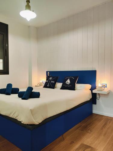 a blue bed with pillows on it in a room at Sea you soon apartment. Lloret de Mar city center in Lloret de Mar