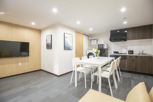 a kitchen and dining room with a white table and chairs at 1min walk to Higashi Shinjuku sta 8PPL Shinjuku Gyoen丶 National Garden丶 Kabukicho丶 Shinjuku Station丶 Golden Gai丶 Tokyo Metropolitan Government Building YYoQB in Tokyo